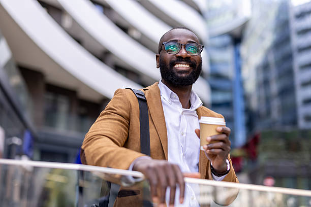 istock Confident Man Smiling with Coffee and Tablet in City 2212704353
