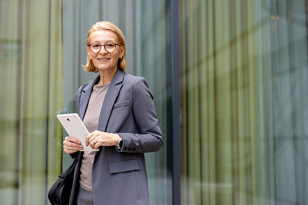 istock Professional Woman with Tablet Smiling in Modern Setting 2212704357