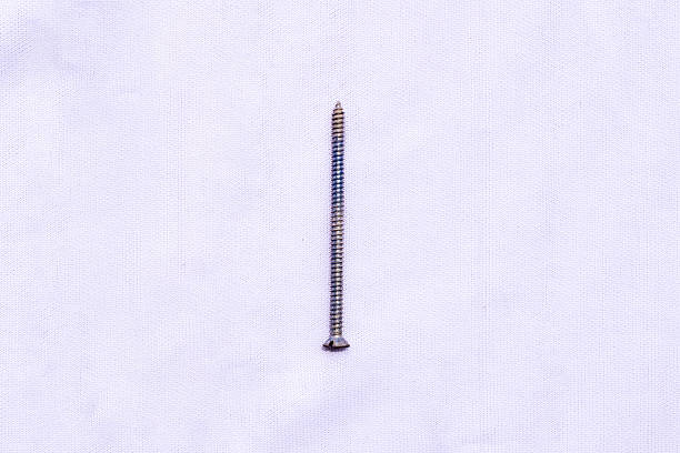 A single silver metal nail screw isolated on a white background  essential hardware for construction