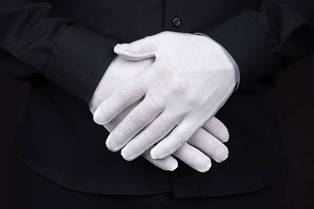istock hand in white fabric gloves on black background Close up 2212704881