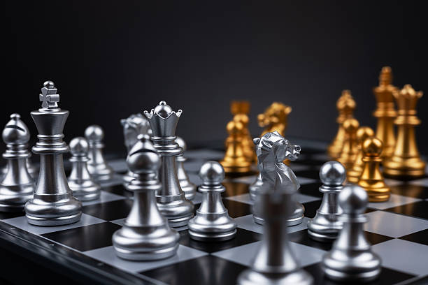 istock Gold and silver chess figures placed on wooden chessboard. Intellectual duel and tactical battle in business. 2212706010
