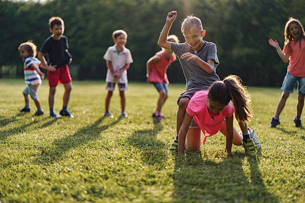 istock Children playing leapfrog game in public park 2212706522