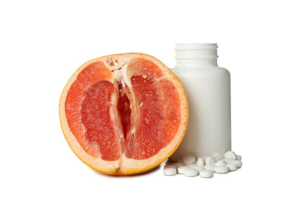 istock PNG, pills next to cut grapefruit, isolated on white background. 2212707244