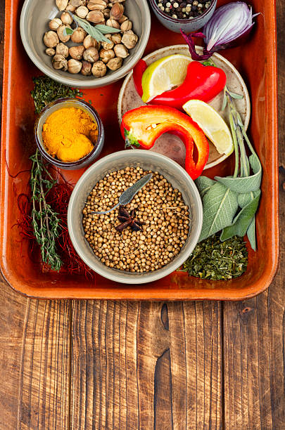 Overhead view of food ingredients over colored  labels .  The food ingredients are: brown rice, white rice, rolled oats, yellow peas, chickpeas, split peas, salt, shredded coconut, chocolate chips, sesame, slivered almonds, cashew, chia, quinoa, coffee beans, raisins, whole wheat, cinnamon stick hibiscus flower, green tea, star anise, cloves, ground coffee, black peppercorns, oregano, garlic cloves, wheat flour, garlic powder, brown sugar, birdseed, bay leaves, sunflower seeds. Image made in studio