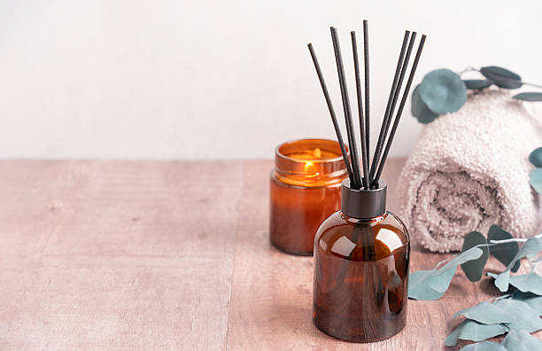 istock Cozy spa setup with aroma diffuser, glowing candle, towel and eucalyptus on table with copy space 2212713644