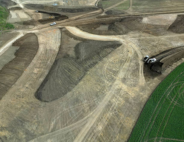 istock preparation of highway construction. soil removal from fields. transportation and leveling of terrain. field areas are decreasing and protection of agricultural land is insufficient. transport infrast 2212715607
