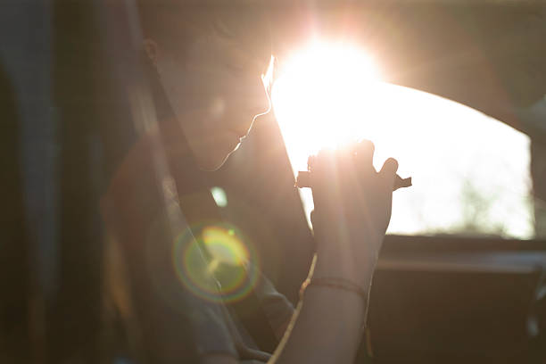 istock A person sitting in a car with a beautiful sunlight background behind them 2212717479