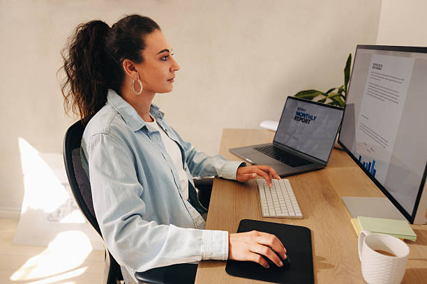 istock Female office worker focusing on computer tasks at her modern workplace 2212719739