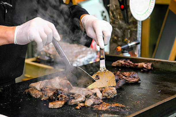 istock Chef cooking beef steak on a hot pan in a restaurant kitchen 2212722325
