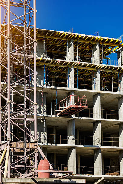 istock Extensive scaffolding providing platforms for work in progress on a new apartment block,Tall building under construction with scaffolds,Construction Site of New Building 2212724824