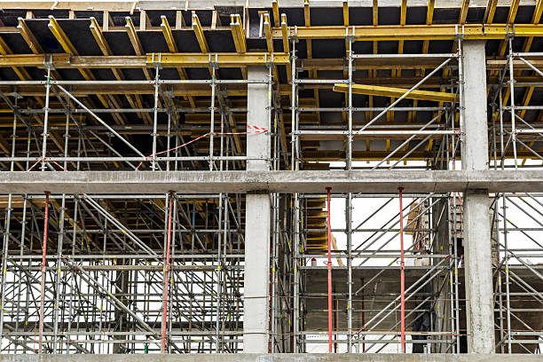 istock Extensive scaffolding providing platforms for work in progress on a new apartment block,Tall building under construction with scaffolds,Construction Site of New Building 2212724888