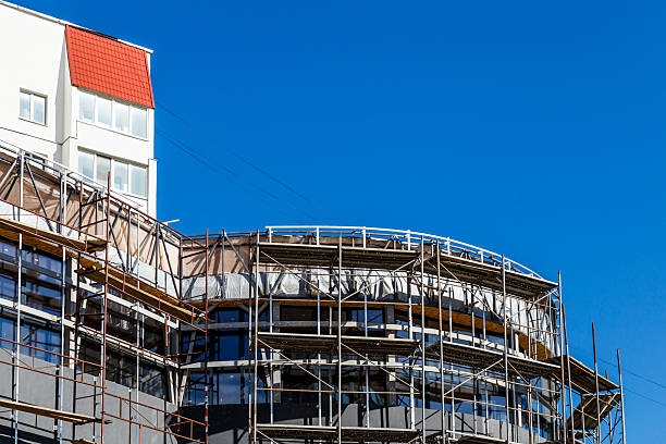 istock Extensive scaffolding providing platforms for work in progress on a new apartment block,Tall building under construction with scaffolds,Construction Site of New Building 2212725175