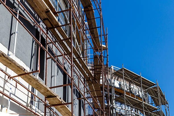 istock Extensive scaffolding providing platforms for work in progress on a new apartment block,Tall building under construction with scaffolds,Construction Site of New Building 2212725183