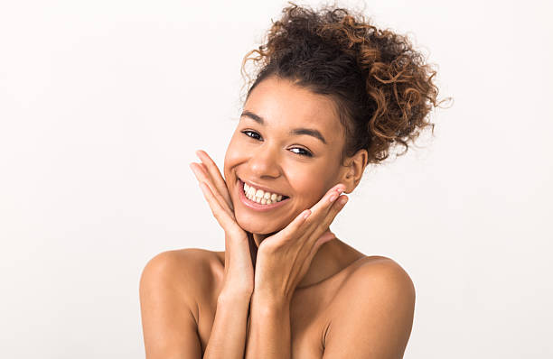 istock Smiling Young Woman Showing Joy and Confidence Against a Light Background 2212725678