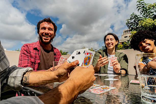 istock Friends talking and playing cards games on rooftop 2212727379