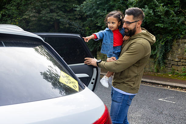 istock Father Joyfully Lifting Smiling Daughter from Car 2212730278