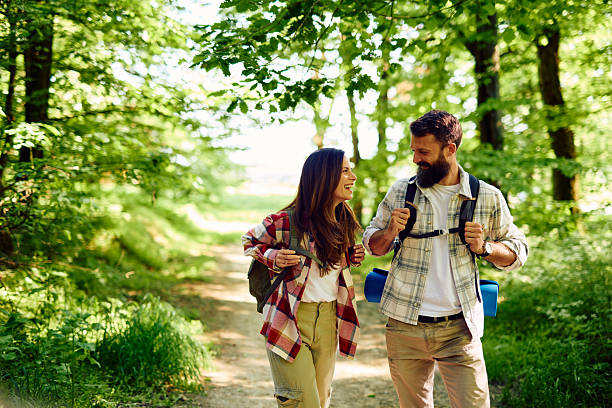 istock Hikers couple walking and talking in the forest 2212731212