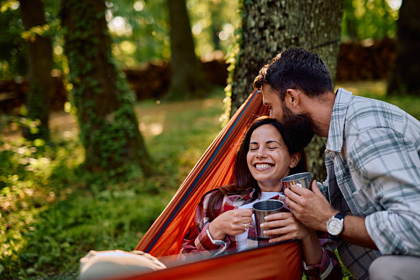 istock Couple relaxing in hammock, drinking coffee and enjoying camping in nature 2212732979