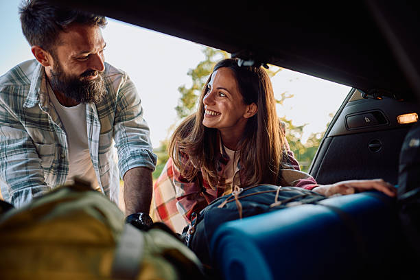 istock Couple loading backpacks and camping gear into car trunk 2212735529