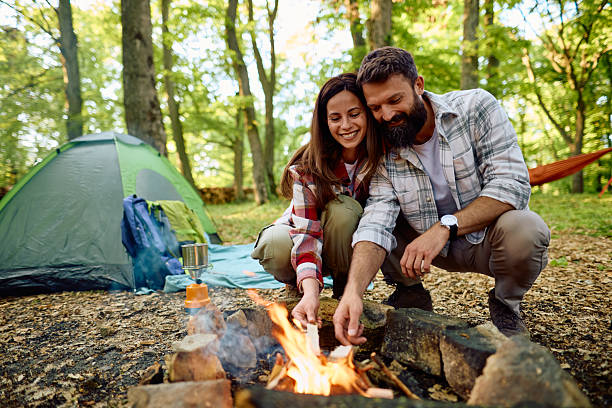 istock Couple camping and lighting bonfire in the forest 2212735772