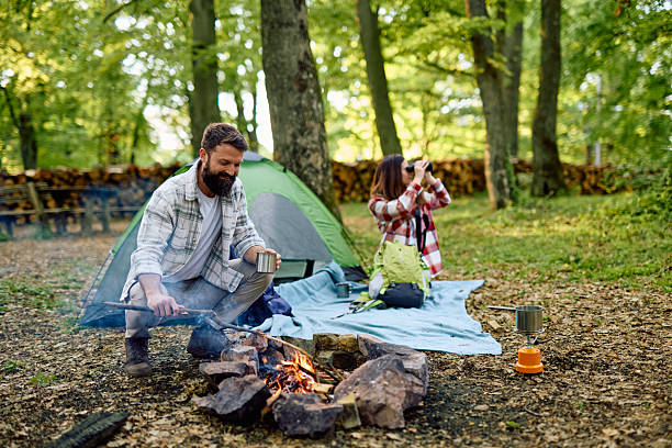 istock Couple camping and enjoying a campfire in the forest 2212737000