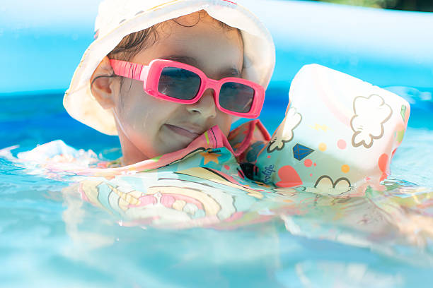 istock Little girl having fun in the pool. 2212737579