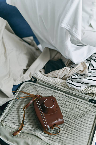 Close-up Shot of Half Packed Suitcase and Vintage Camera