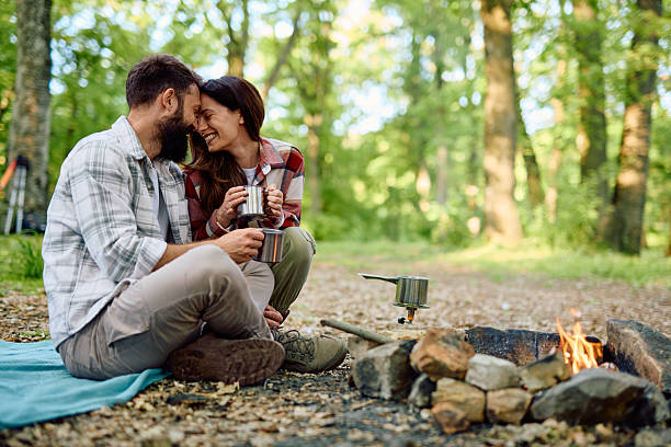 istock Couple enjoying hot drinks while camping in the woods 2212739797