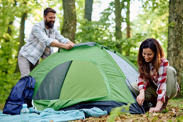 istock Couple setting up tent in forest during camping trip 2212739900