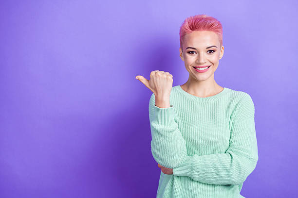 istock Photo of cute cheerful person beaming smile indicate thumb finger empty space teal pullover isolated on violet color background 2212741878