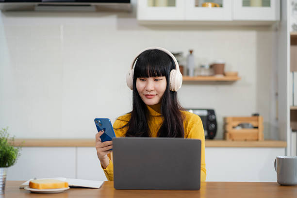 istock Smiling woman in headphones taking notes, motivated interested student studying online, using tablet, watching webinar training or listening to lecture, remote education concept. 2212744760