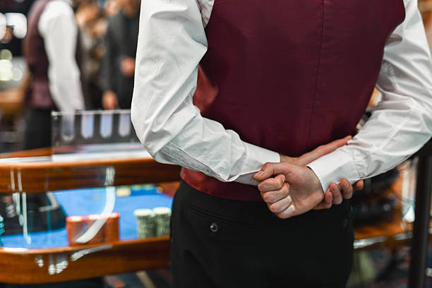 Casino Dealer Standing by Game Table with Chips in View