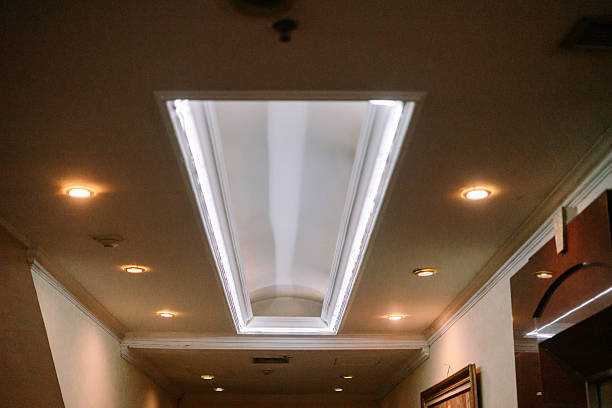 A view of the building ceiling featuring a geometric skylight and glowing ambient lights