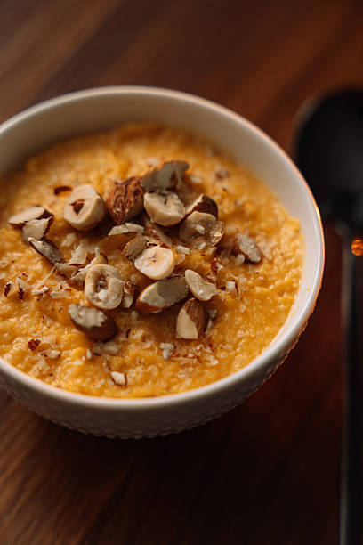 istock corn porridge with nuts in a white bowl, vertical photo 2212757133