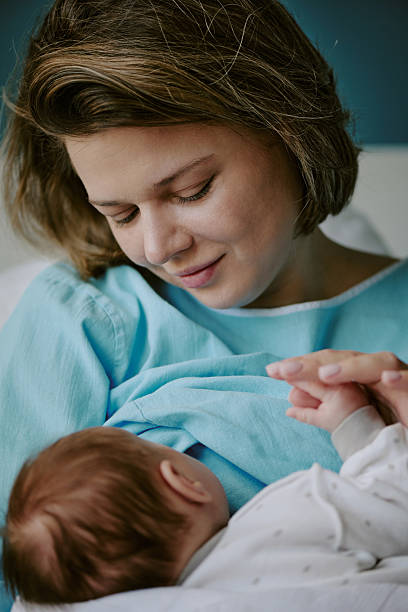 istock Mother Cradling Newborn Baby with Gentle Expression 2212759631