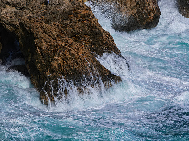 istock beautiful waves crashing on rocks 2212764750