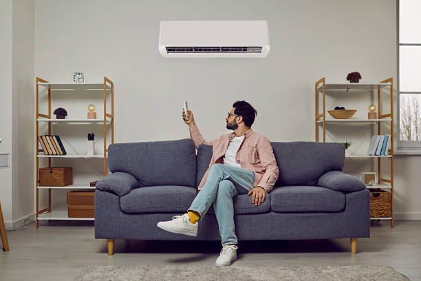 istock Man enjoys using newly installed air conditioner and sets comfortable temperature in his home. 2212765673