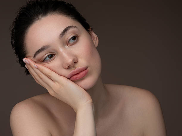 istock Thoughtful woman with bare shoulders resting her head on her hand 2212766007