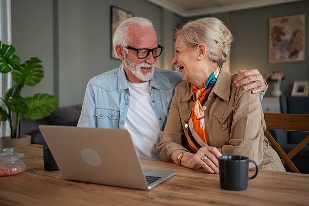 istock Happy senior couple laughing and using laptop at home 2212766237