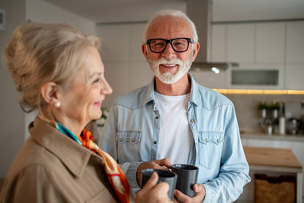 istock Happy senior couple enjoying coffee together in modern kitchen 2212766341