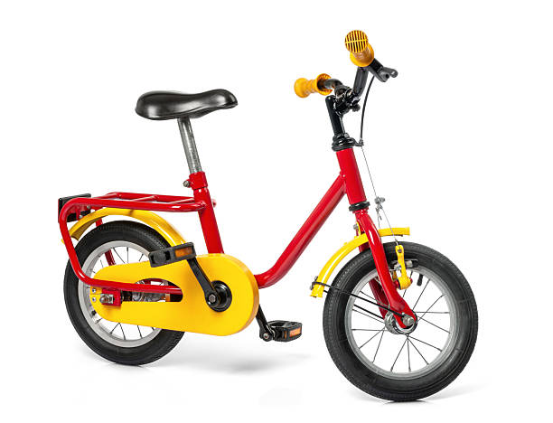 istock Bright red and yellow children's bicycle with a sturdy frame, black saddle, and small wheels, isolated on white background. File contains a path to isolation. 2212768777