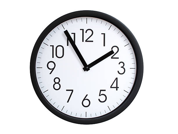 Simple round wall clock with black frame and white face, showing the time exactly at 01:55 or 13:55. Representing time precision in concepts of deadlines.