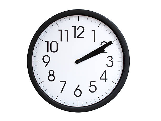 Simple round wall clock with black frame and white face, showing the time exactly at 02:10 or 14:10. Representing time precision in concepts of deadlines.