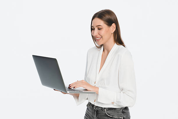 istock Smiling Woman Using a Laptop in a Bright Minimal Setting 2212772531