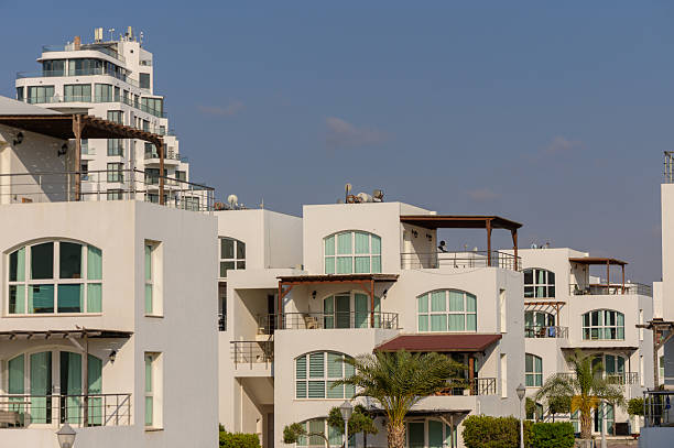 Elegant white villas in traditional Mediterranean style with red tile roofs, located on sunny Cyprus island.