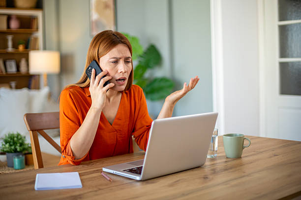 istock Stressed businesswoman arguing on phone while working at home 2212772876