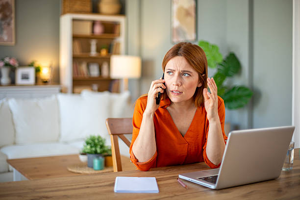 istock Frustrated woman arguing on phone while working from home 2212773026