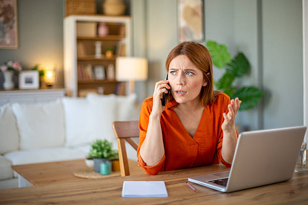 istock Stressed businesswoman arguing on phone while working from home 2212773052
