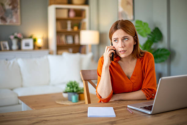 istock Businesswoman talking on the phone while working from home 2212773053