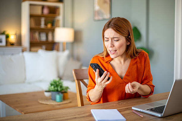 istock Frustrated woman talking angrily on mobile phone at home office 2212773379